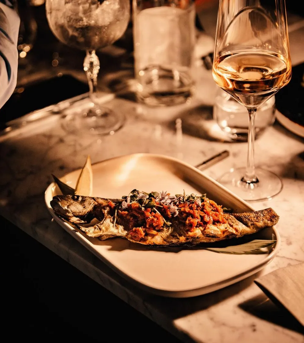 Une assiette servie à table, un verre de vin à côté